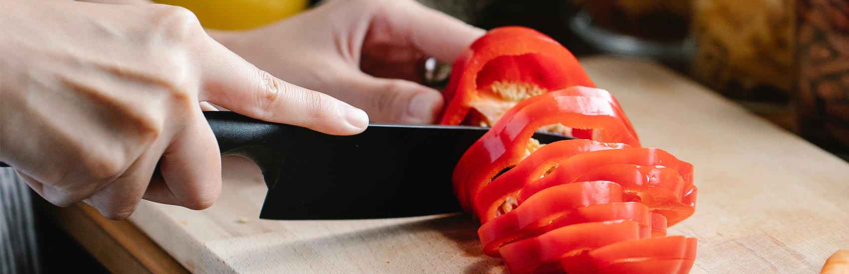 Tomatoes being sliced on a cutting board